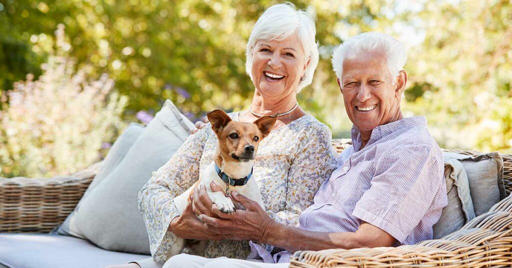 Ein Seniorenpaar mit Hund freut sich