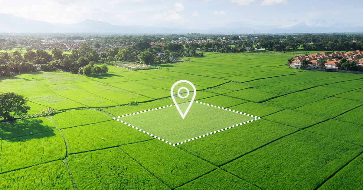 Luftaufnahme eines unbebauten, grünen Grundstücks mit markierter Fläche und Standort-Symbol, das die Entwicklungsmöglichkeiten und den gezielten Verkauf von Bauland veranschaulicht. | Grundstücksverkauf