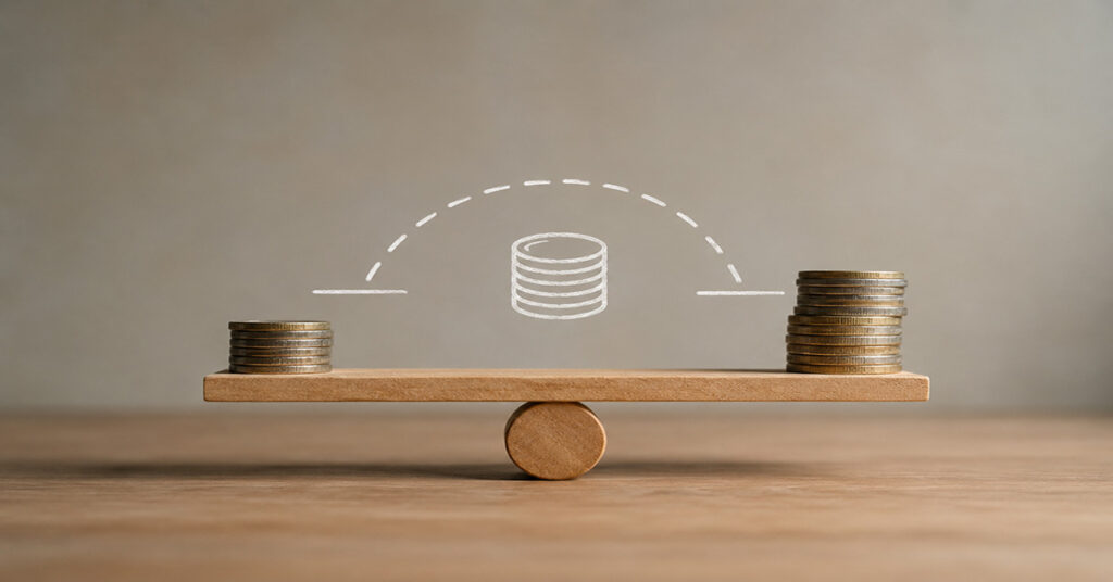 Zwei unterschiedlich hohe Münzstapel auf einer Holzwippe symbolisieren den finanziellen Ausgleich durch eine Zwischenfinanzierung. I Zwischenfinanzierung